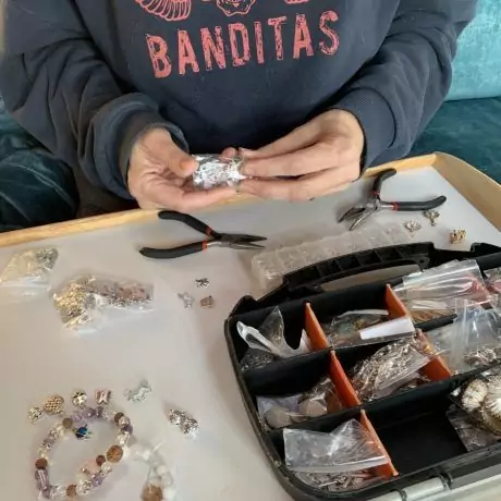 Alex choisit ses perles de pierres naturelles pour son bracelet à la Grotte Forestière